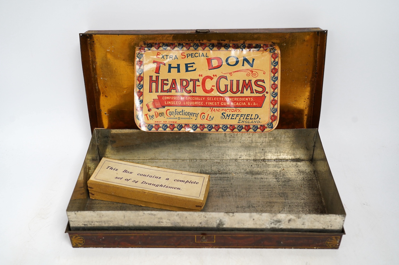 An early 20th century Carrs novelty 'dice game' biscuit tin, a Don Confectionery 'chessboard' tin and a Wright & Son Ltd inkstand tin, largest 33cm wide. Condition - fair